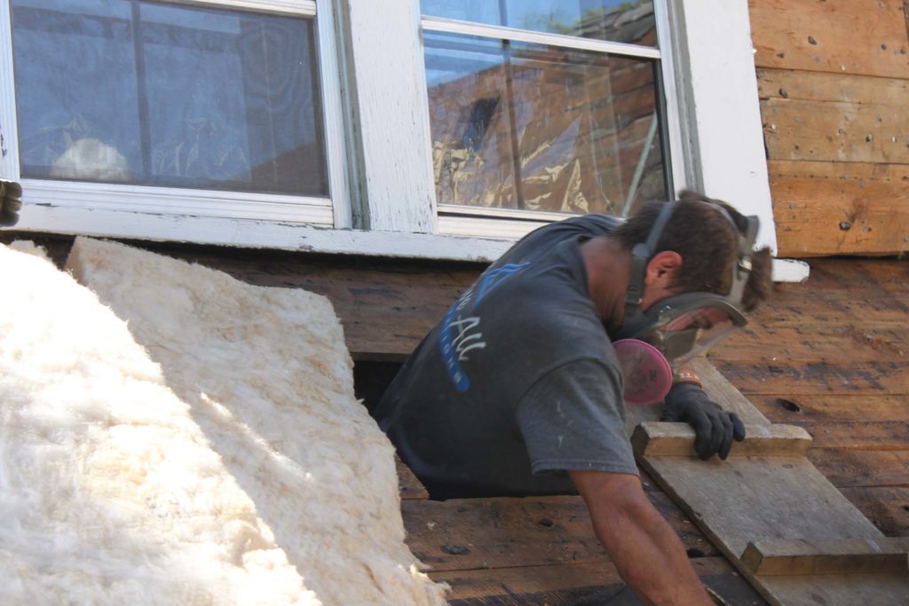 Preparing to take fibreglass batts into a knee-wall chamber for installation on the vertical knee-wall