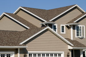 Tan-sided house with asphalt shingle roof.