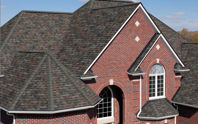 Gray asphalt shingles on a brick home.