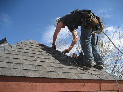 Shingler tanning his tricep while trimming the hip of this roof near Île-des-Chênes.