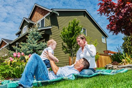 Happy family outside their well-cladded home