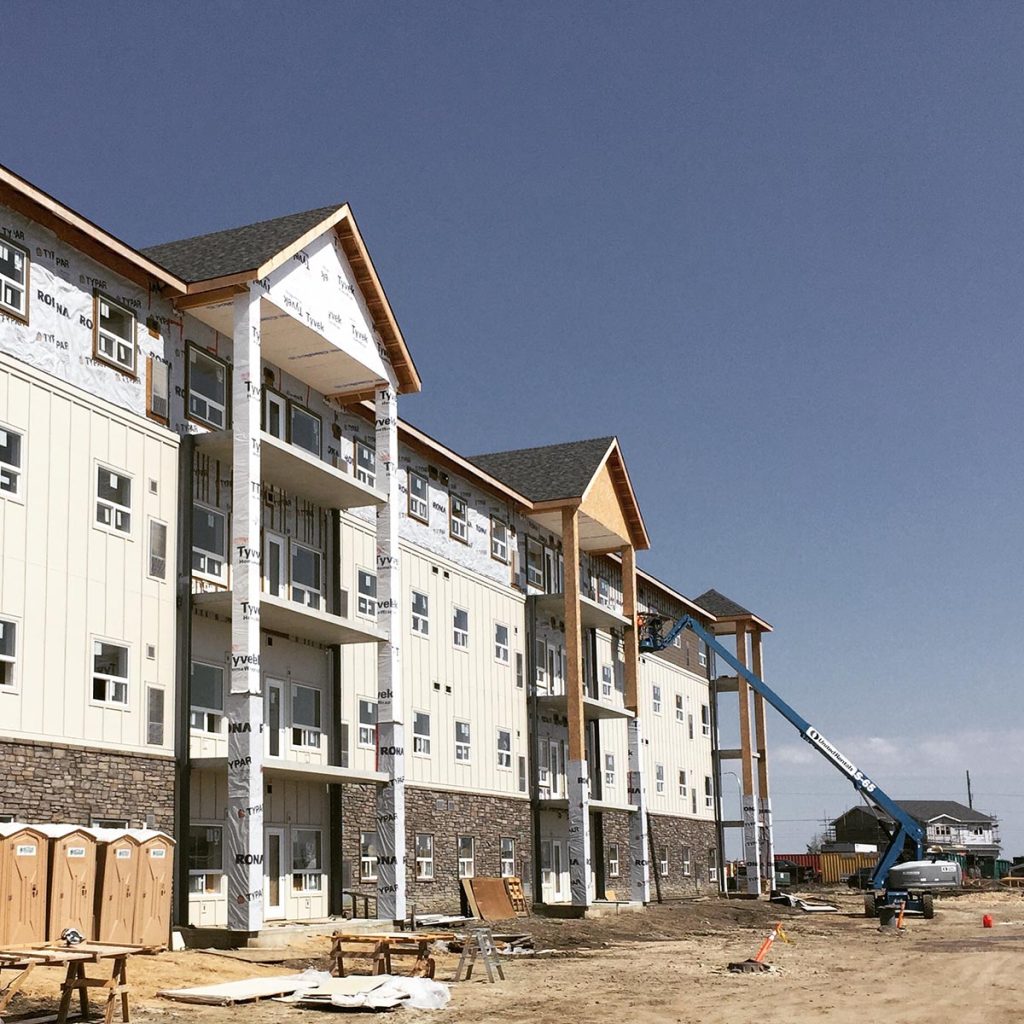 A multi-story apartment building under construction with Typar house wrap installed on the exterior walls.